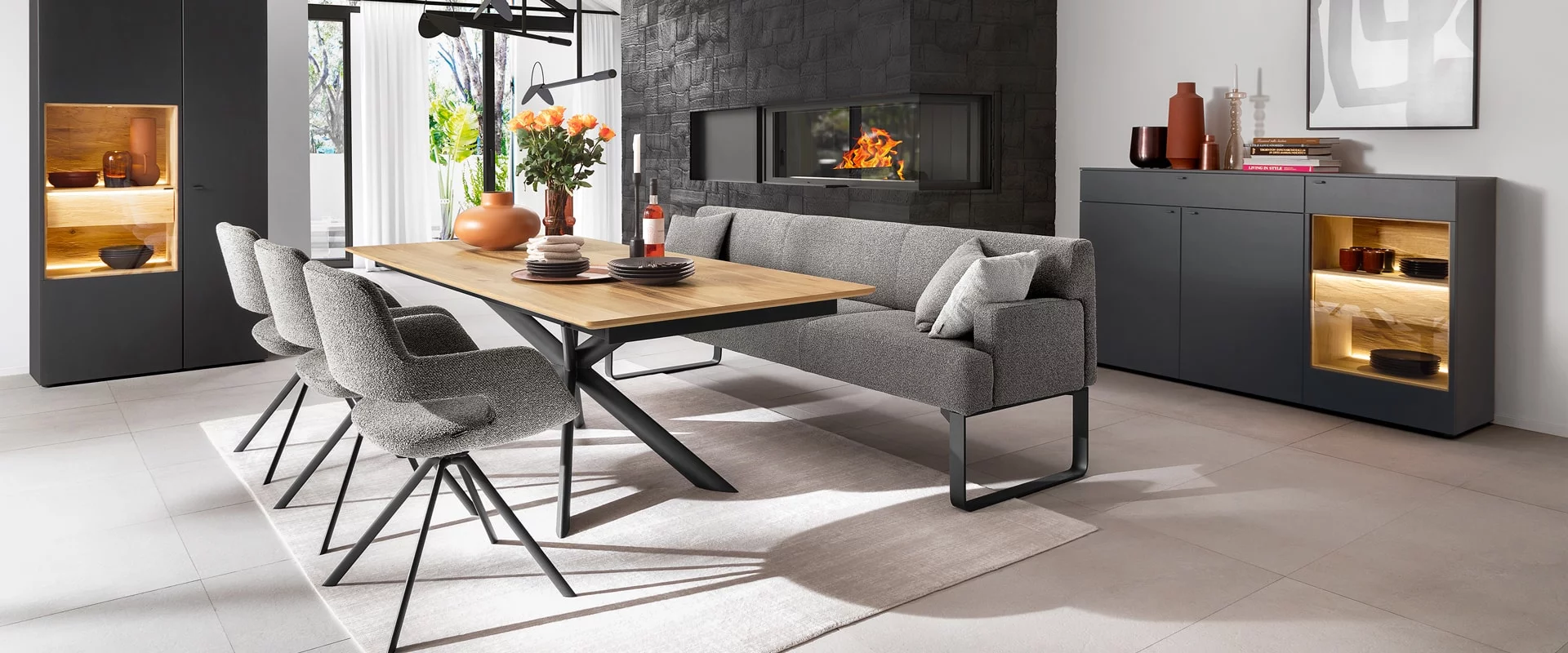 Modernes Esszimmer mit Holztisch grauer Polsterbank und stilvollen Sesseln