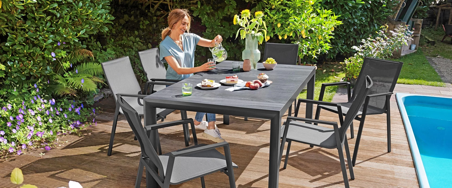 Eine Frau sitzt an einem Gartentisch