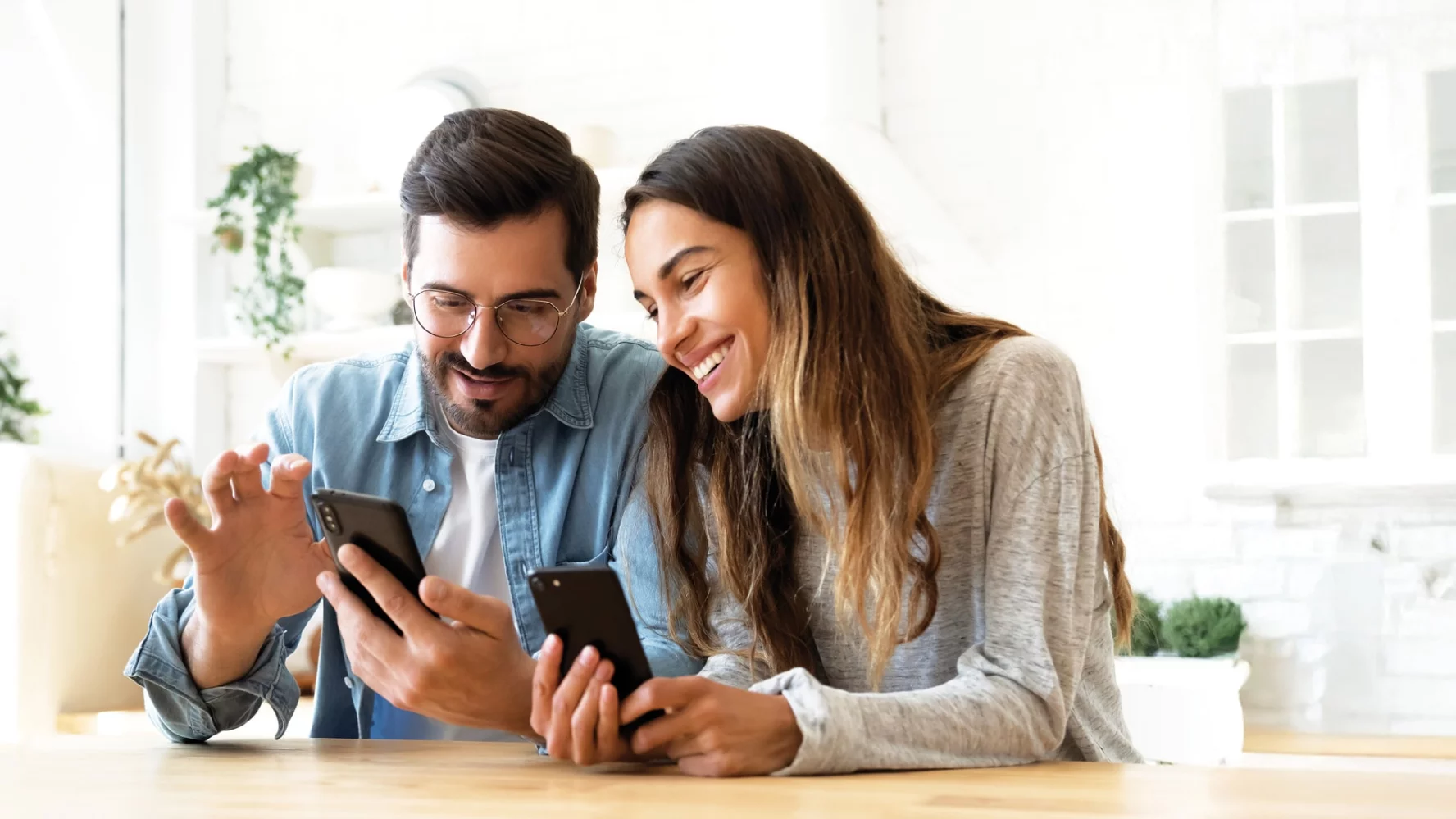 Junges Paar mit Smartphones lesen den Newsletter